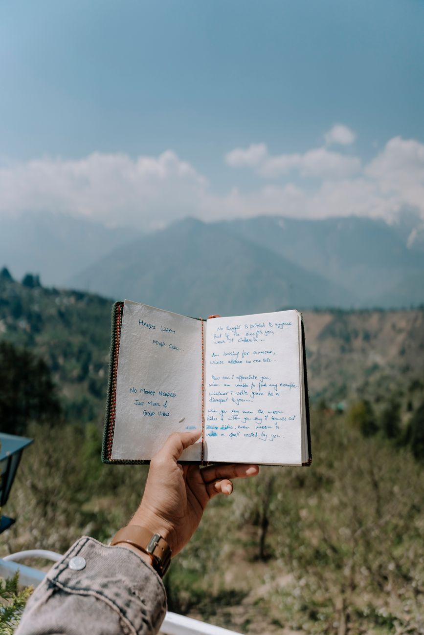 Travel writer reviewing notes on mountain balcony